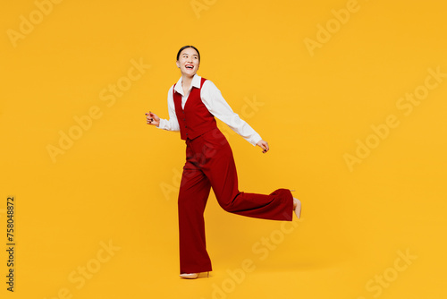 Full body side profile view young lawyer employee business woman of Asian ethnicity wear formal red vest shirt work at office run fast look aside on area isolated on plain yellow background studio.