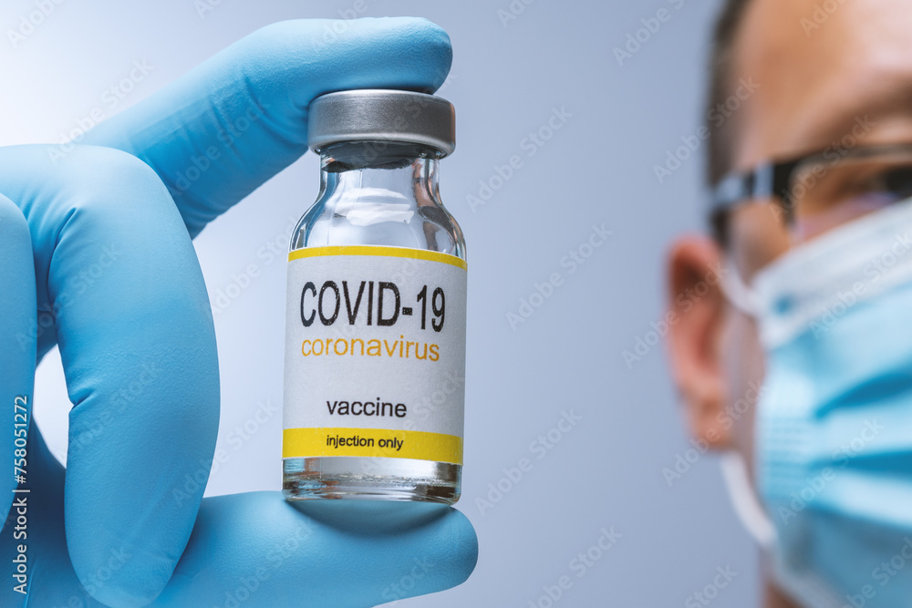 Doctor in blue latex gloves holding glass vial with medicine. Vaccination, immunization, treatment to Covid 19 Corona Virus infection. Healthcare And Medical concept. Doctor in blue latex gloves holding glass vial with medicine. Vaccination, immunization, treatment to Covid 19 Corona Virus infection. Healthcare And Medical concept.