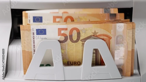 Euro banknotes. Bank automatic equipment for counting cash money. Close-up of 50 euro banknotes counted macro top view slow motion. European union currency. Inflation,  economy, investment, income photo