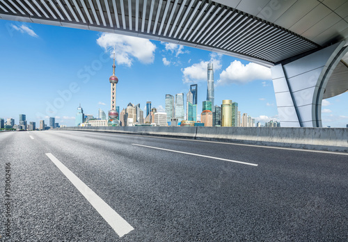 Asphalt highway road and pedestrian bridge with modern city buildings in Shanghai