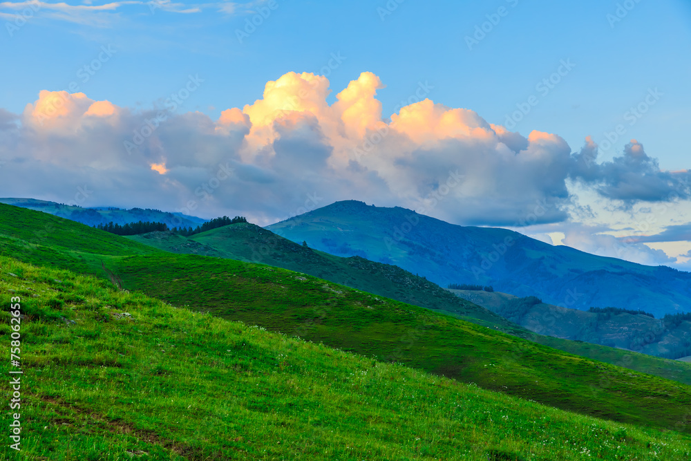 Green grassland and mountain natural landscape at dusk