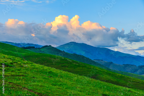 Green grassland and mountain natural landscape at dusk