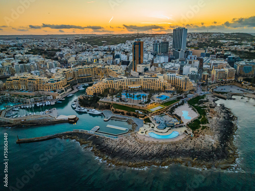 Drone view of St. Julian's city, high buildings. Sunset sky. Malta island