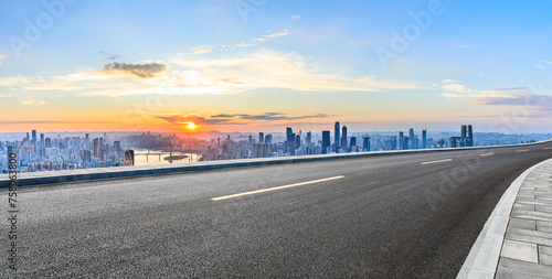 Asphalt road and urban skyline with modern buildings at sunset in Chongqing
