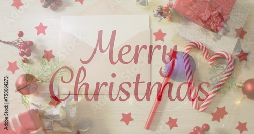 Image of christmas greetings text over envelope, christmas presents and decorations