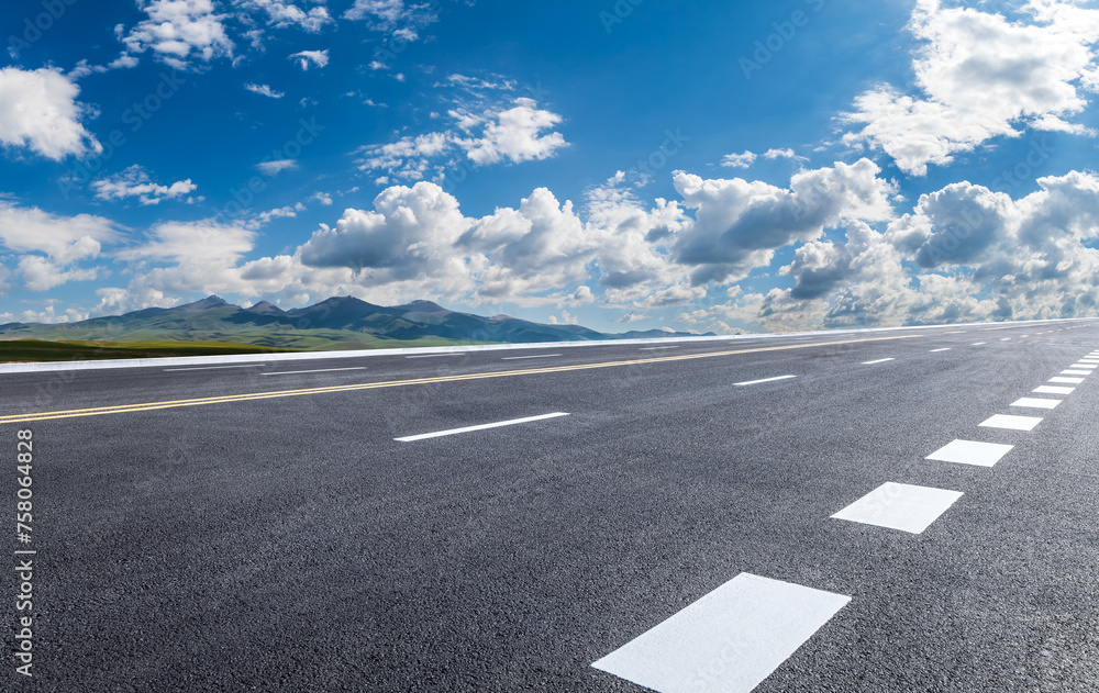 Fototapeta premium Asphalt road and mountain nature landscape under blue sky