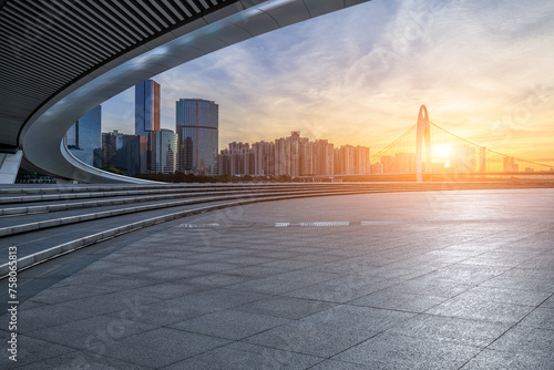 Empty square floor and bridge with modern city buildings at sunrise in Guangzhou
