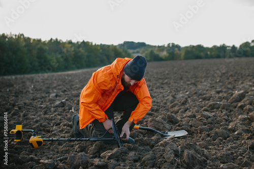 Young man treasure hunter doing archeology in the field.