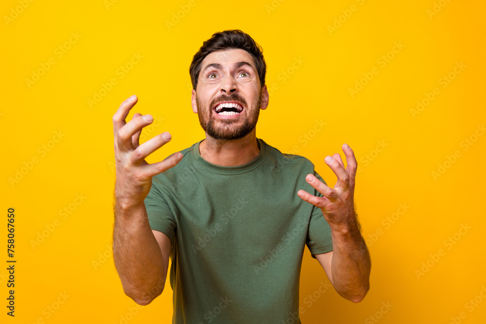 Fototapeta premium Photo of furious abusive guy dressed green t-shirt screaming looking up empty space isolated yellow color background