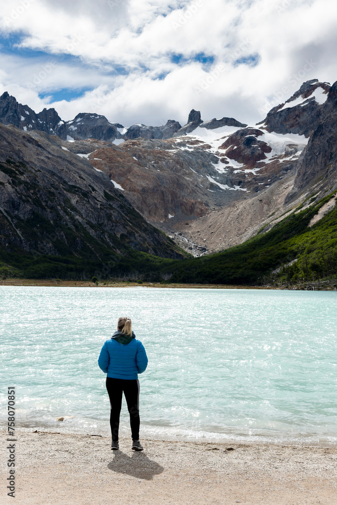 woman contemplating and walking through beautiful landscape of mountains forests rivers and bridges lifestyle of traveling ushuaia argentina end of the world