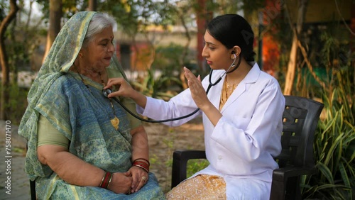 Beautiful Indian lady doctor examining an old woman in village - nurse  government hospital doctor  ilaaj. Old age grandmother visiting her doctor for regular checkup - full body checkup  heart rat...