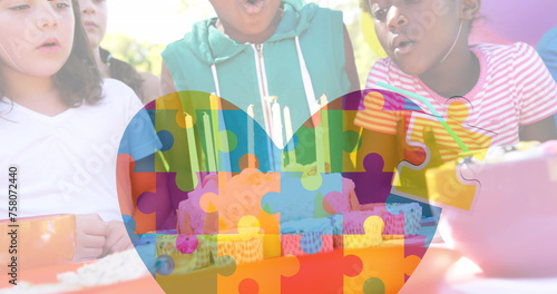 Image of colourful puzzle pieces and heart over kids friends on birthday