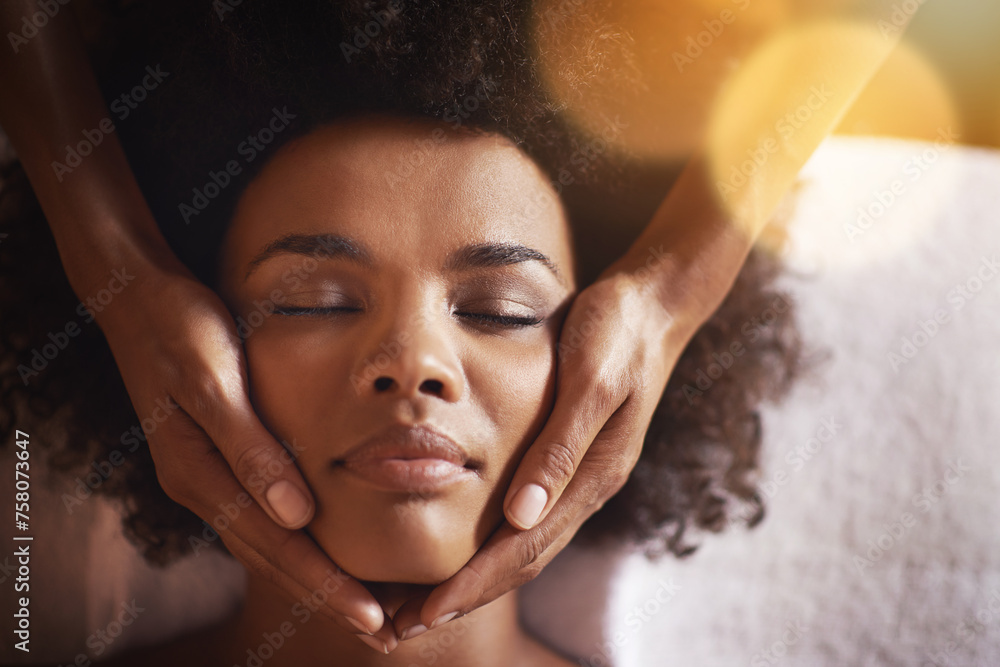 Woman, relax and massage on face with hands and care for facial, wellness and spa treatment on bed. Above, lens flare and african female person with skincare and cosmetics at hotel with skin glow - obrazy, fototapety, plakaty 