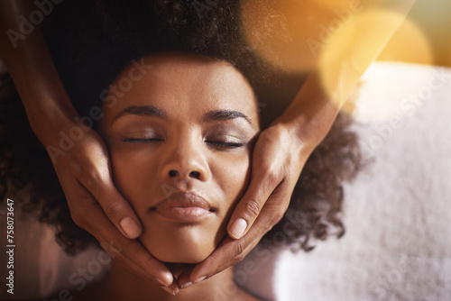 Woman  relax and massage on face with hands and care for facial  wellness and spa treatment on bed. Above  lens flare and african female person with skincare and cosmetics at hotel with skin glow