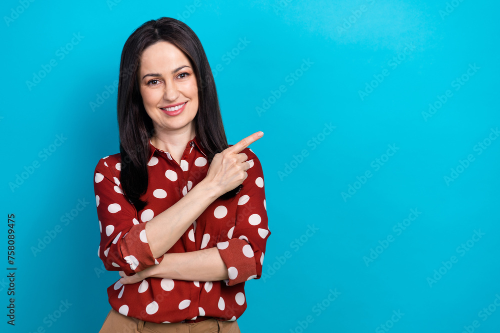 Photo portrait of attractive woman point empty space billboard dressed stylish dotted red clothes isolated on blue color background Photo portrait of attractive woman point empty space billboard dressed stylish dotted red clothes isolated on blue color background