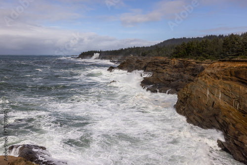 The ocean is rough and the waves are crashing against the rocks