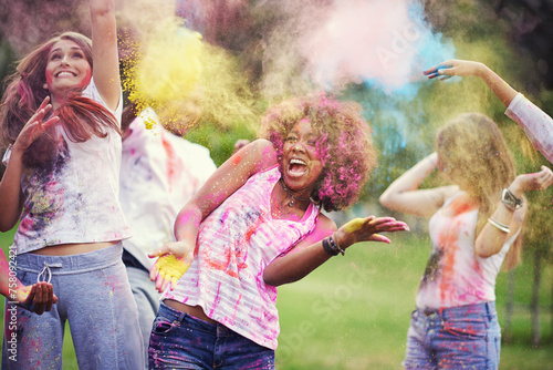 Friends, happiness and powder paint at color festival in park, fun with celebration or party outdoor. Freedom, bonding and colorful mess in nature, joy and culture with people at summer event photo