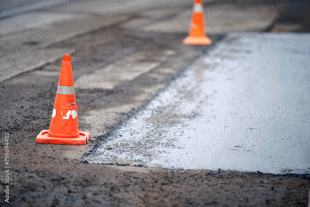Traffic cones separated repaired section of asphalt road from cars ...
