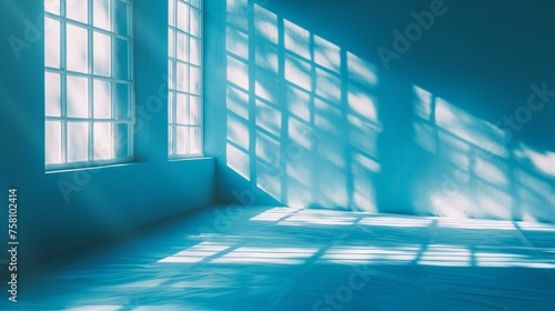 Minimalist abstract light blue background for product presentation with light and shadow from windows on wall.