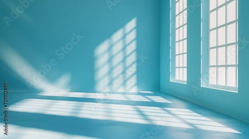 Minimalist abstract light blue background for product presentation with light and shadow from windows on wall.