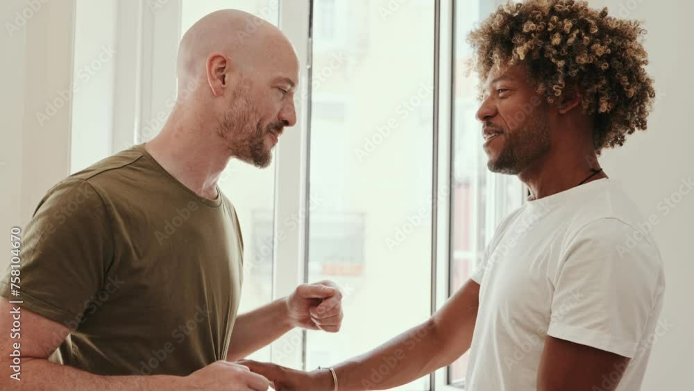 A diverse gay couple enjoys dancing together at home, radiating love and togetherness in a cozy atmosphere. A diverse gay couple enjoys dancing together at home, radiating love and togetherness in a cozy atmosphere.