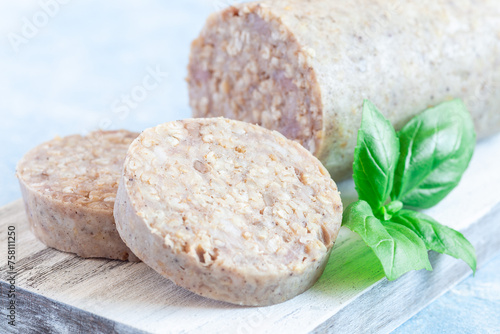 Foto Traditional Irish white or oatmeal pudding sausage slices on a wooden board, hor