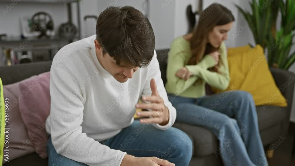 A man and woman engage in a tense conversation in a modern living room, hinting at relationship issues. A man and woman engage in a tense conversation in a modern living room, hinting at relationship issues.