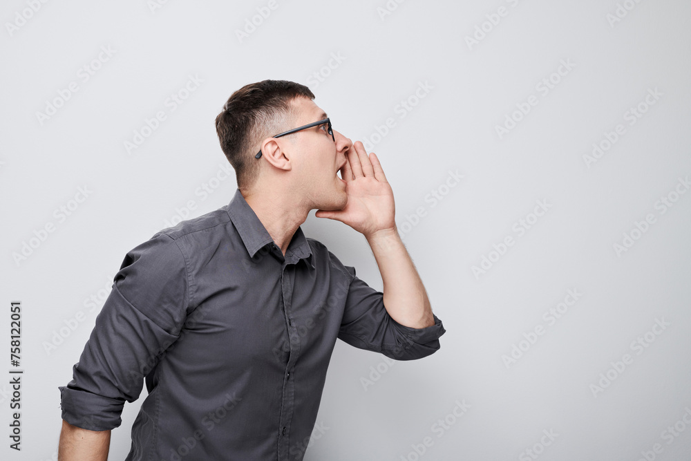 Portrait of handsome man shouting loudly with hands, news, palms folded like megaphone isolated on white background Portrait of handsome man shouting loudly with hands, news, palms folded like megaphone isolated on white background