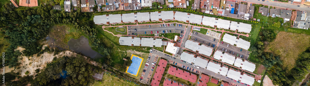 Panorámica aérea tomada en Colombia. Urbanización popular con acceso a montaña y lago - obrazy, fototapety, plakaty 