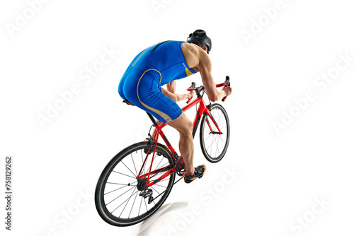 Fototapeta Naklejka Na Ścianę i Meble -  Back view image of concentrated sportsman in blue sportswear and helmet in motion on bike isolated on white studio background. Concept of sport, active and healthy lifestyle, speed, endurance, hobby