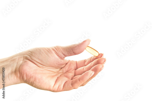 Female hand holding Omega 3 capsule isolated on white background. Close up. High resolution product.
