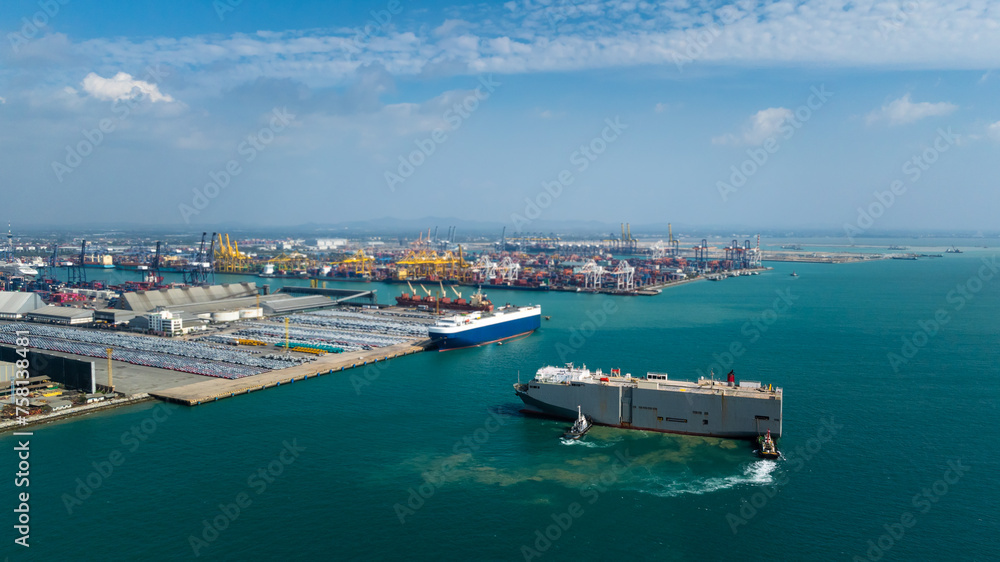 tugboat pushing Roll-on Roll-of  ship into the port. Automotive container carriers floating in sea, new car lined up in the port for import and export to dealership for sale,