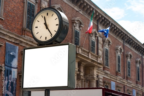 Blank white poster under a clock in Milan.