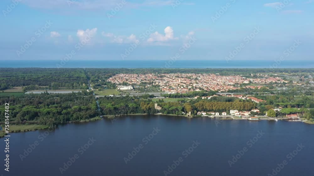 Beautiful drone view of Torre del Lago Puccini on the coast of Tuscany with Apuane Alps and a clear blue sky of a spring day, with Massaciuccoli Lake and Mediterranean Sea Beautiful drone view of Torre del Lago Puccini on the coast of Tuscany with Apuane Alps and a clear blue sky of a spring day, with Massaciuccoli Lake and Mediterranean Sea