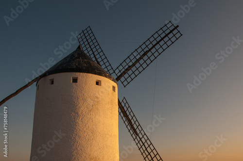 Traditional whitewashed winmill at dusk. Son Quixote famous windmill of Campo de Criptana, Castilla La Mancha, Spain. photo
