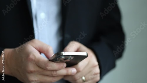 Close up shot of businessman hand using smartphone, checking email, chatting online, texting with a client