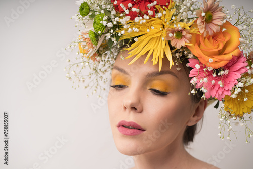  A half-closed gaze under a magnificent floral crown conveys a tranquil and graceful poise. The flowers' colors softly blend with the woman's natural beauty.