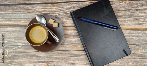 tasse de café et agenda sur une table en bois. Vue du dessus.