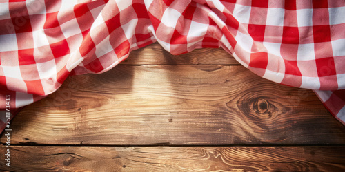  A red and white checkered tablecloth  on a wooden background with copy space, banner photo