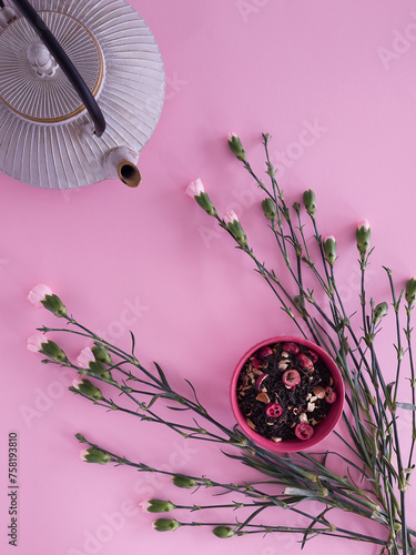 Tea composition on a pink background with carnations flowers. Spring flat lay. photo