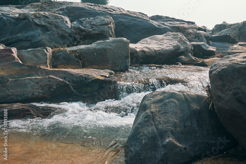 flow of Telwa river stream falling through levels of rocky terrain at Dharhara falls in Simultala, Bihar. Water level is knee-deep as flow of water is mostly dried-up in winter season. photo