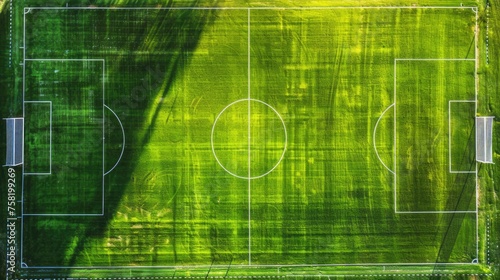 an aerial view of a vibrant green soccer field, showing the lines marking the playing areas, including the center circle, penalty areas, and the goals