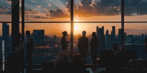 A silhouette of a business team in an office with a large window overlooking a cityscape. The image captures the team in various postures of interaction and collaboration photo