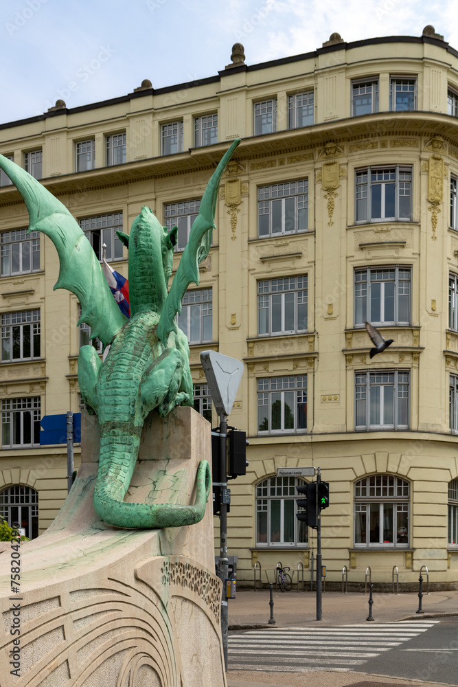 Naklejka premium Ljubljana, Slovenia; The Ljubljana Dragon Bridge spans the Ljubljanica River, Ljubljana Central Market and Saint Nicholas's Cathedral (Katedrala Sv. Nikolaj), dragon sculpture