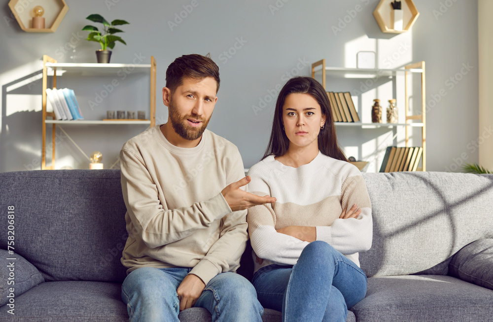 Family couple discussing relationship problems in online therapy. Young man and woman sitting in front of camera on couch at home, having remote therapy session, talking about their misunderstandings Family couple discussing relationship problems in online therapy. Young man and woman sitting in front of camera on couch at home, having remote therapy session, talking about their misunderstandings