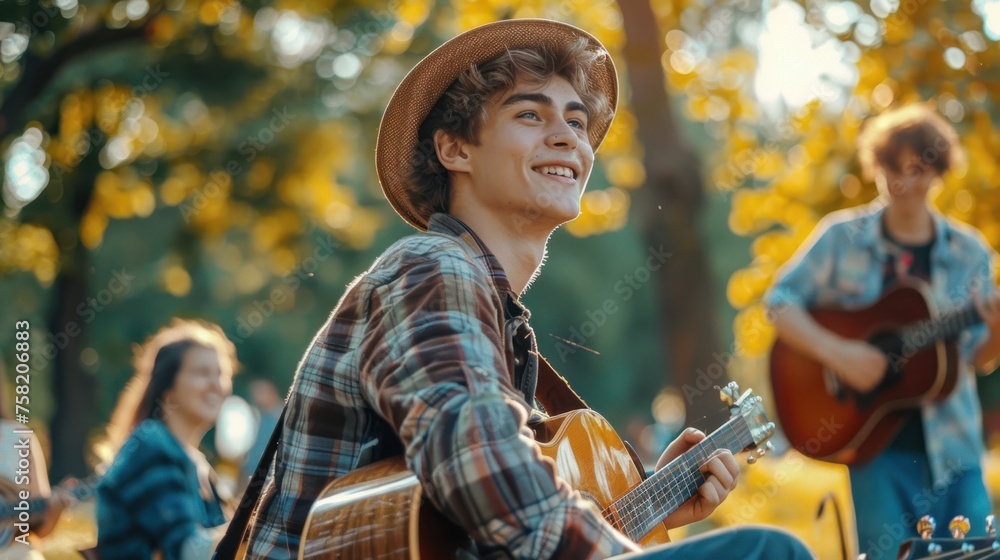 a young man playing guitar with friends in the park on a sunny day. Outdoor activities,