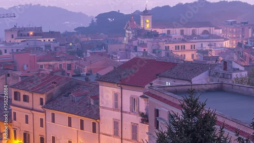 Dusk to Night Elegance: Duomo di San Pancrazio Martire Timelapse, Albano Laziale, Italy. Aerial View of Old House Roofs in the Tranquil Transition from Day to Night on a Summer Evening photo