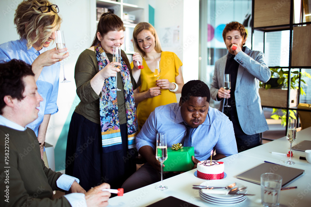 Office birthday celebration with colleagues enjoying cake and champagne Office birthday celebration with colleagues enjoying cake and champagne
