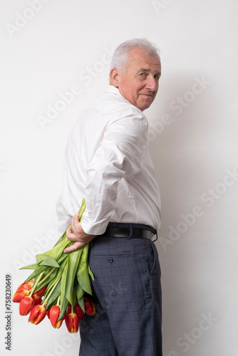 Handsome old man with a bouquet of tulips.