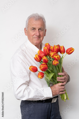 Handsome old man with a bouquet of tulips.